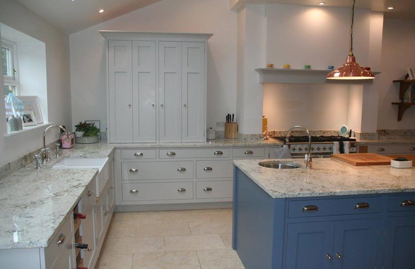 fitted kitchen with marble surfaces and blue cupboards